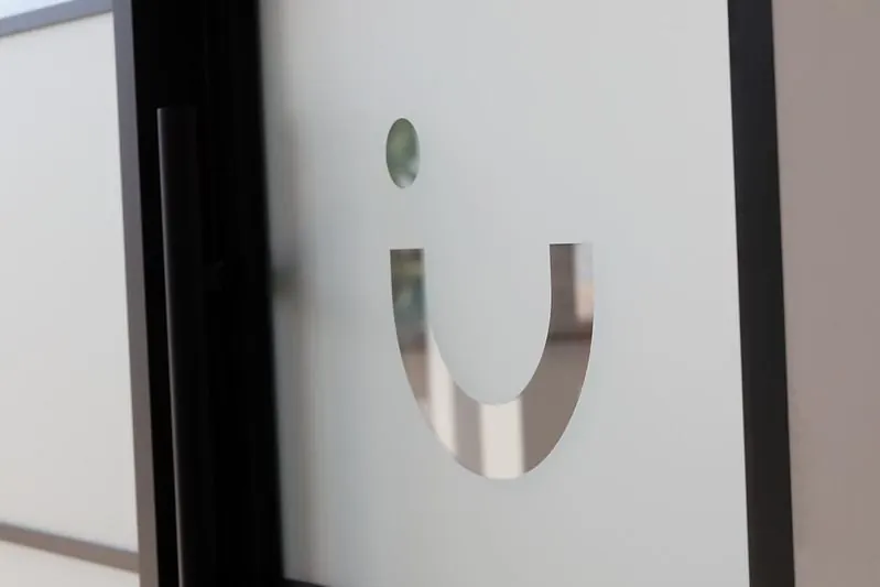 The Radiant Dental smile logo on frosted glass inside the Winnipeg clinic